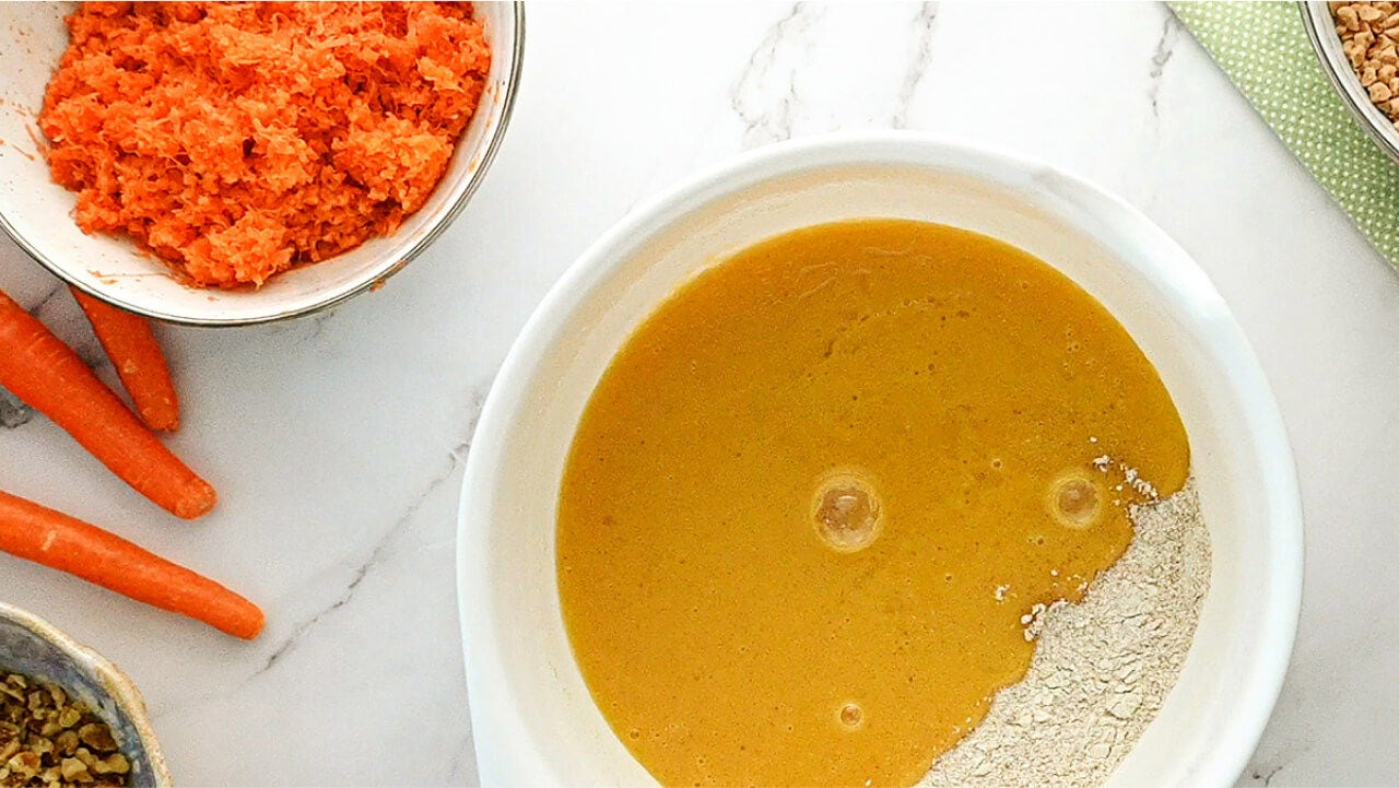 bowl of freshly shredded carrots and carrot cake batter