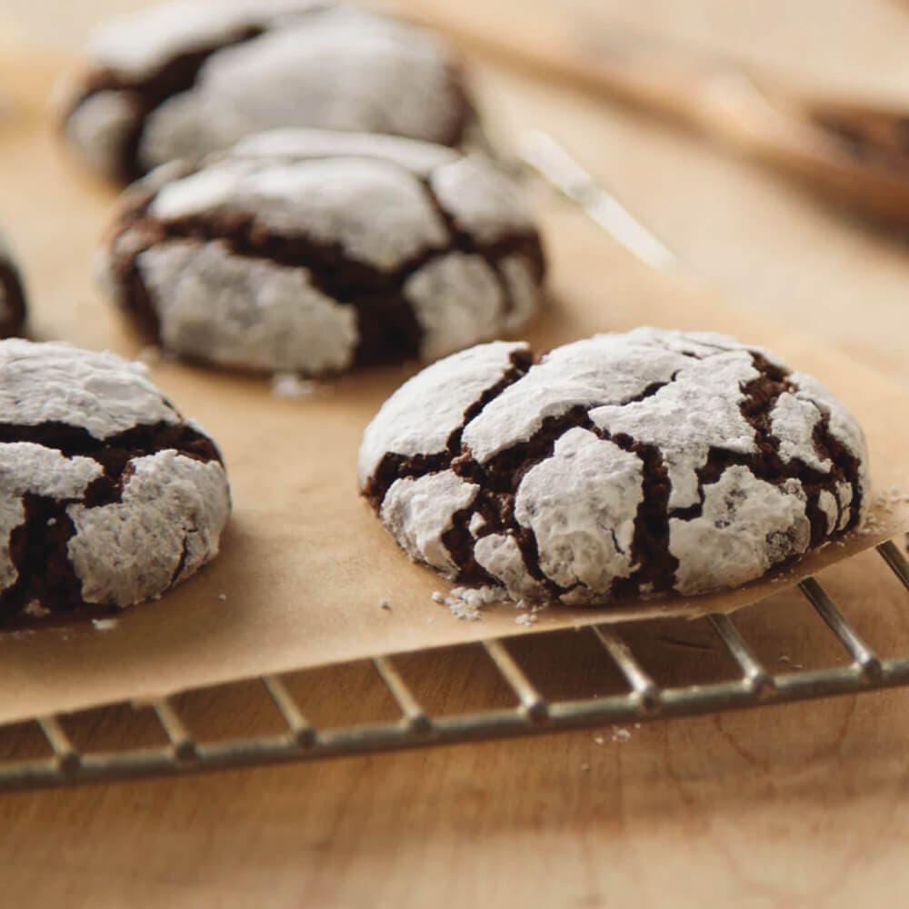 batch of cocoa crinkle cookies cooling on wire rack