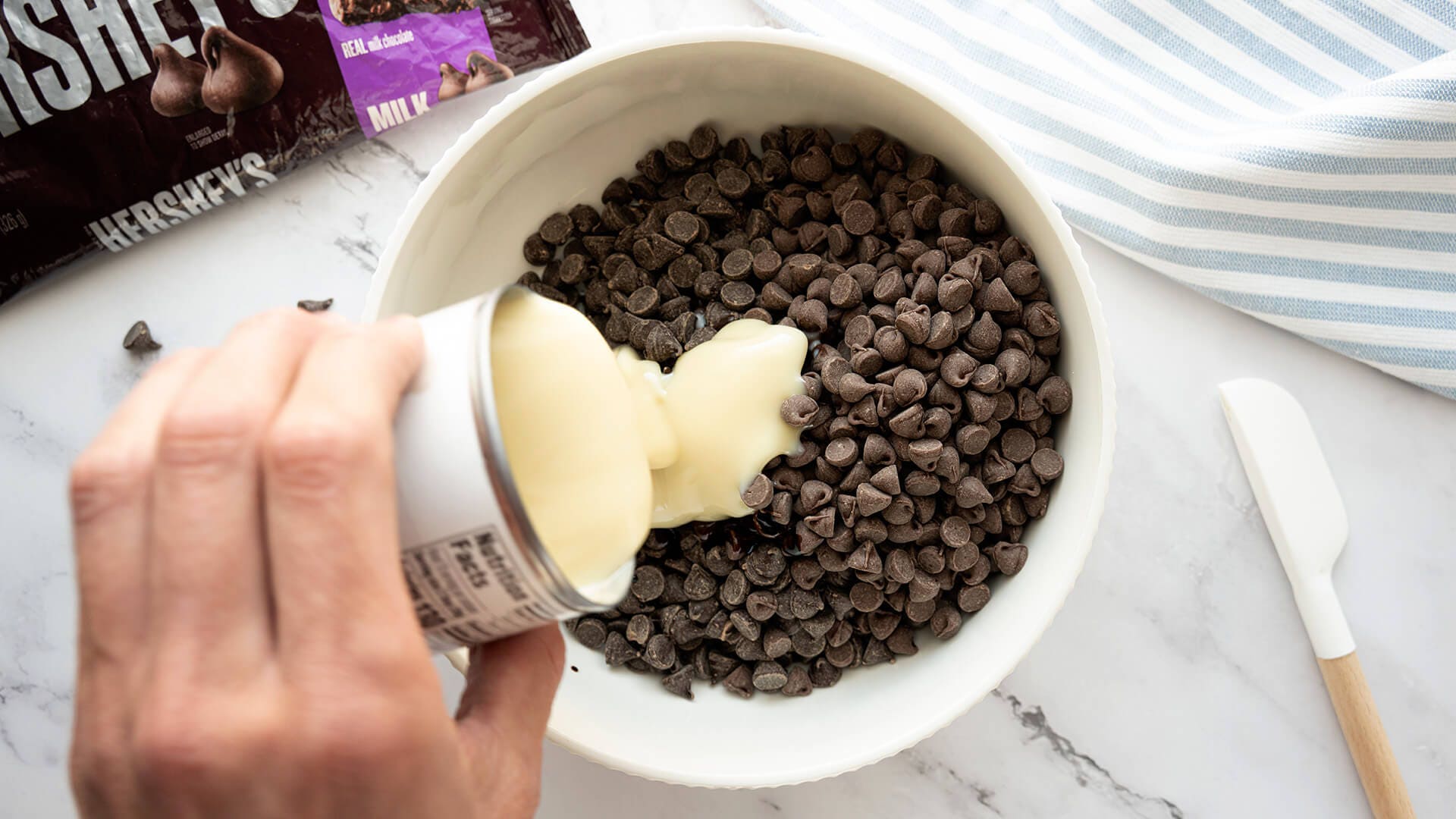 condensed milk added to bowl of chocolate chips