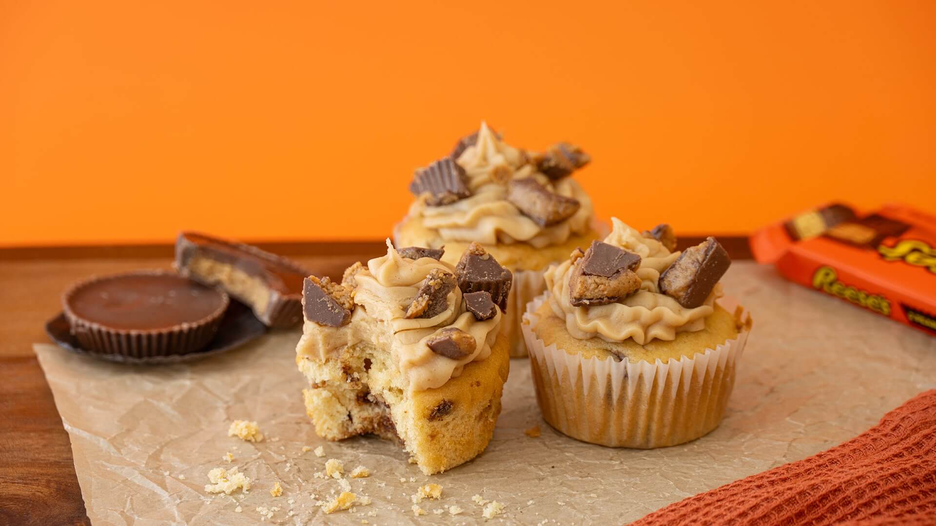 3 reeses peanut butter cup crumble cupcakes on parchement paper