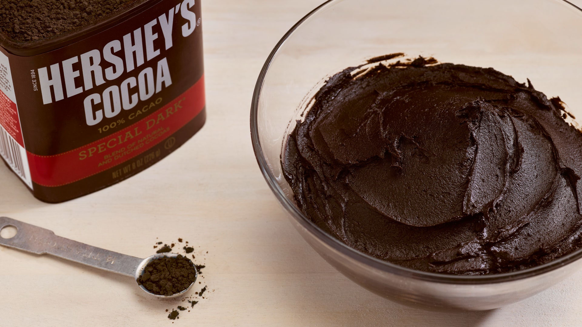 bowl of chocolate frosting made with hersheys special dark cocoa 