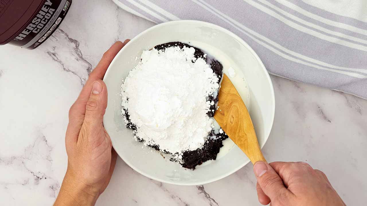 adding powdered sugar and milk into the mixture