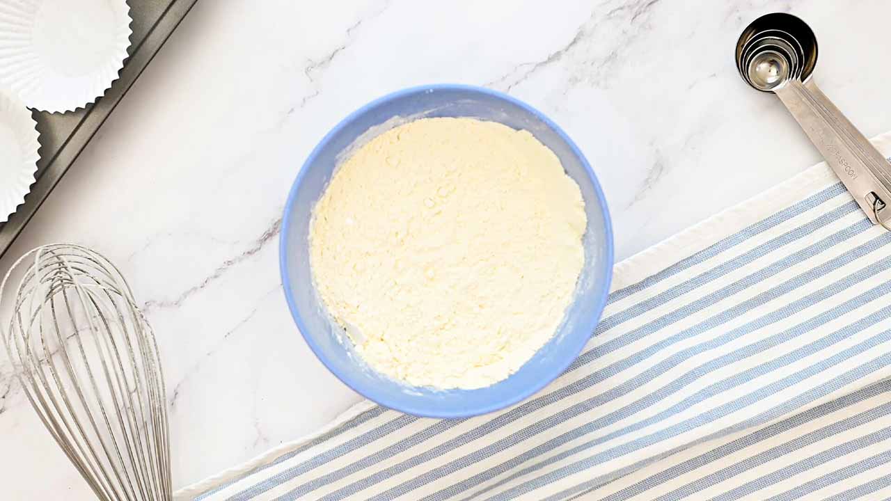 mixing together dry ingredients including all purpose flour, baking powder, and salt
