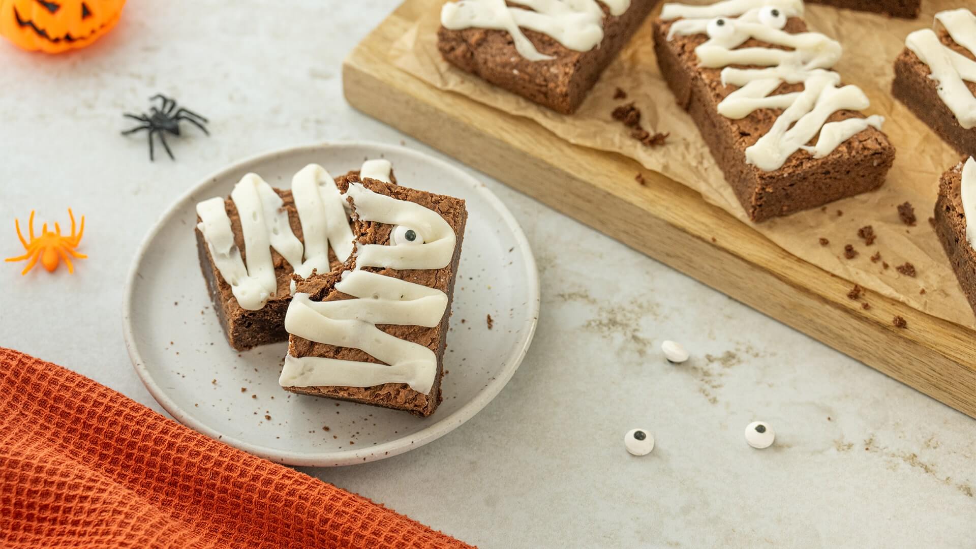 plated mummy brownies with a bite taken out of one