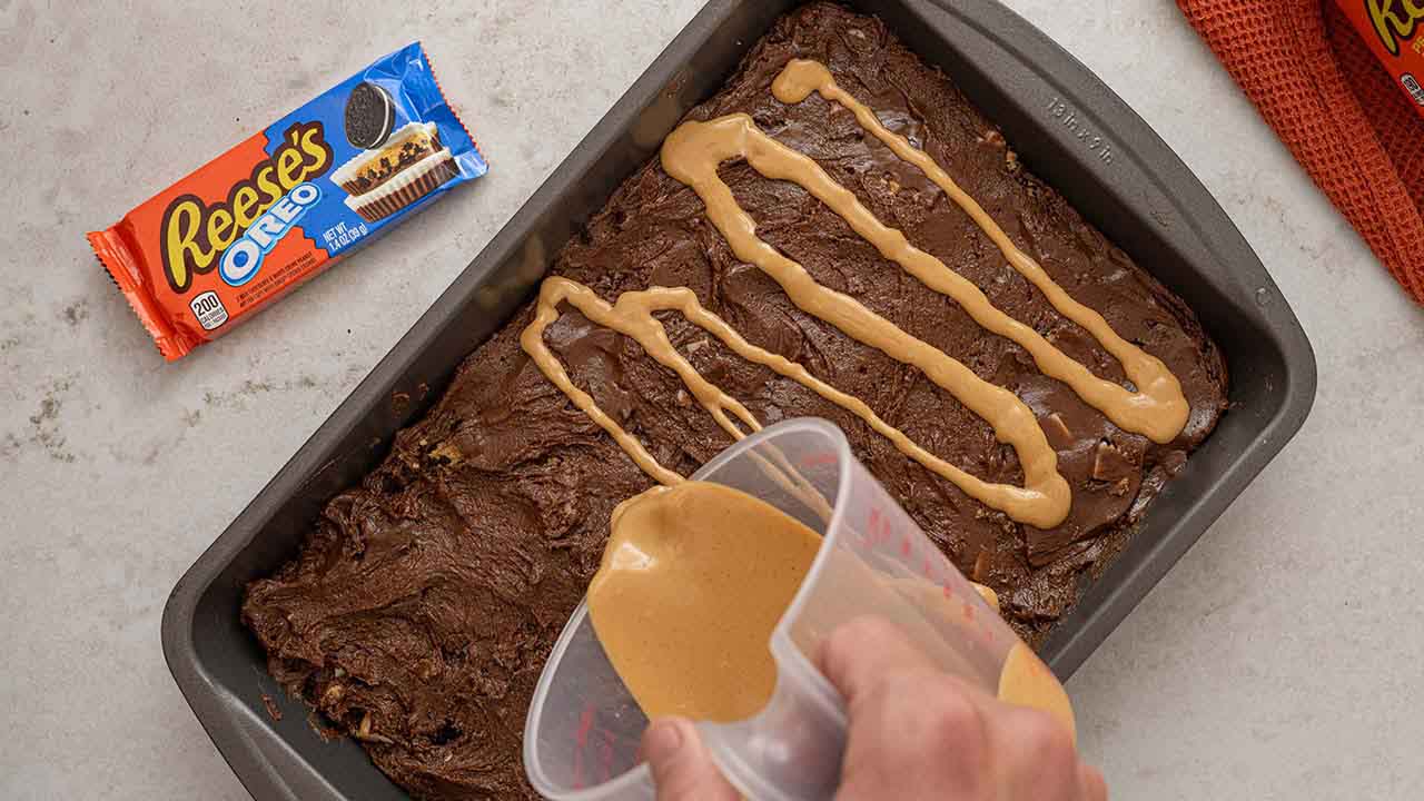 drizzling peanut butter on top of the brownie batter