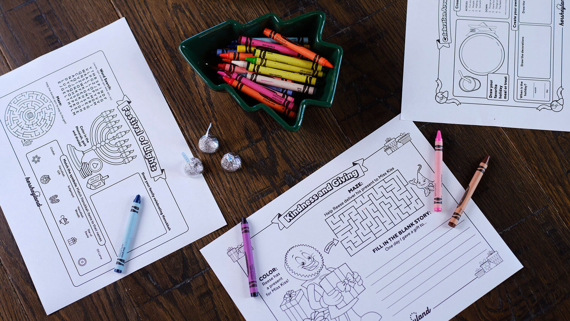 coloring pages on wooden table with bowl of crayons and bowl of hersheys kisses