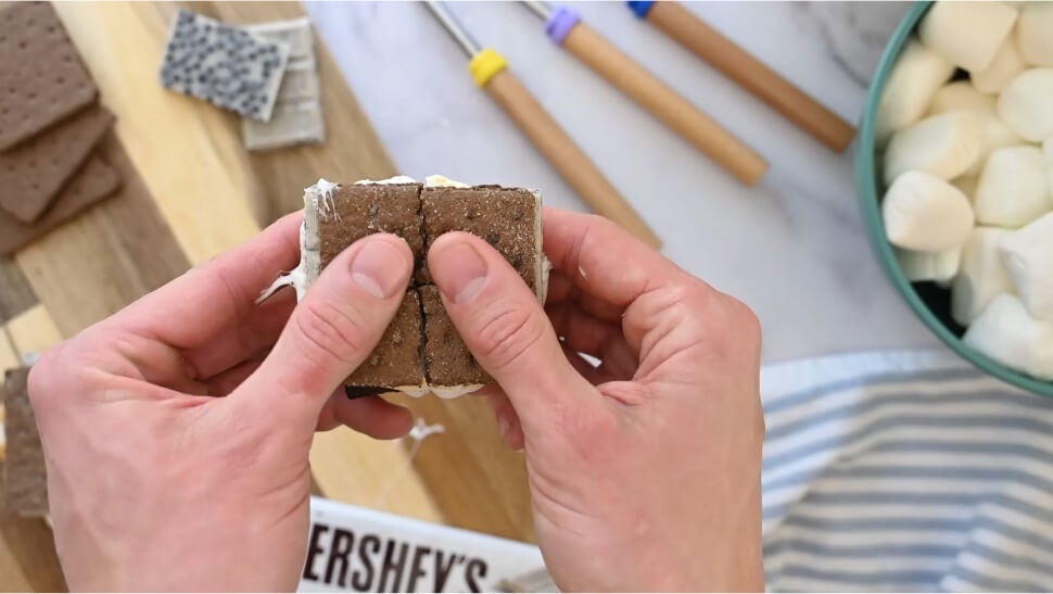 person breaking a cookies n creme flavored air fryer smore in half