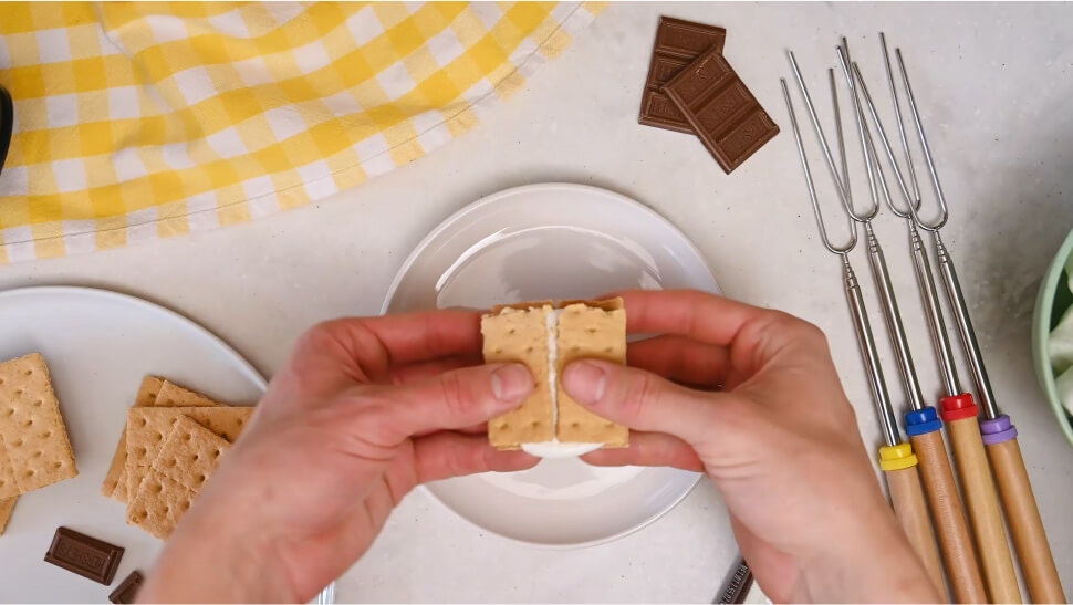 person breaking a classic flavored microwave smore in half