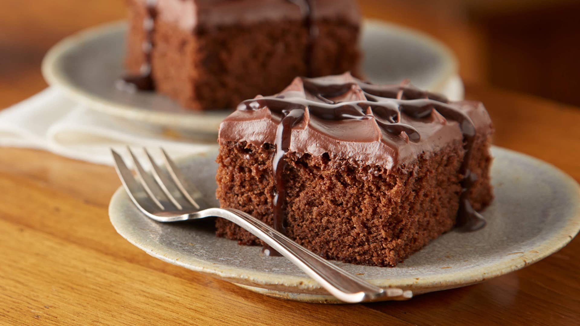 icedchocolate cake squares drizzled with hersheys chocolate syrup