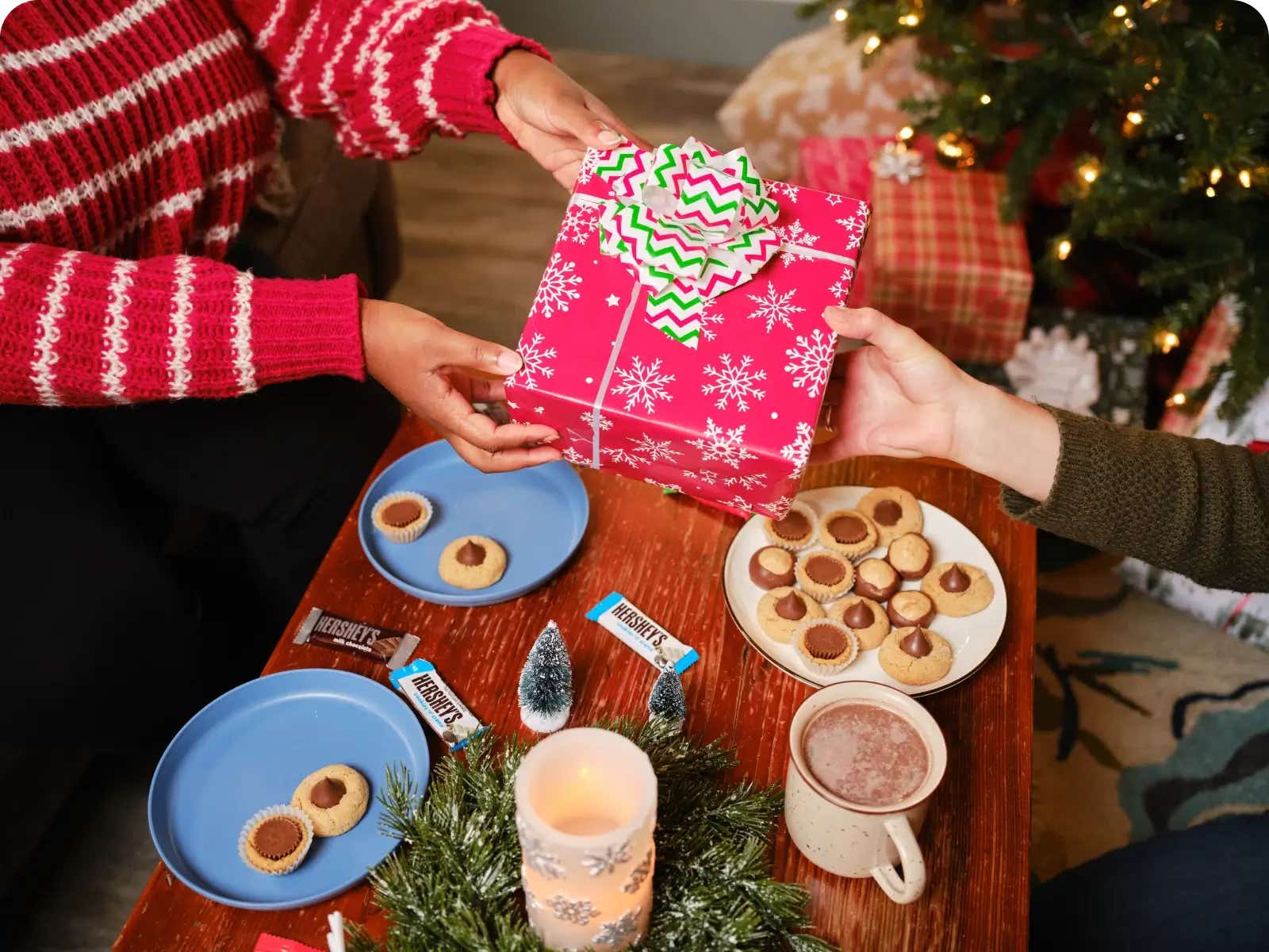 people echanging gift over plates of holiday cookies